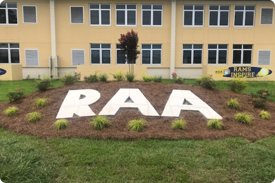 Letters RAA in the landscaping of a school building